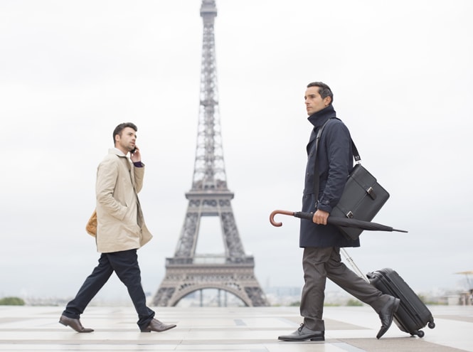 two men walking in front of the Eiffel Tower