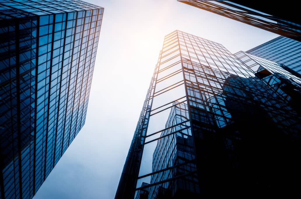 Looking up at the towering glass facades of modern skyscrapers