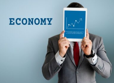 economy concept: a businessman holding a tablet with a stock market exchange graph on the screen